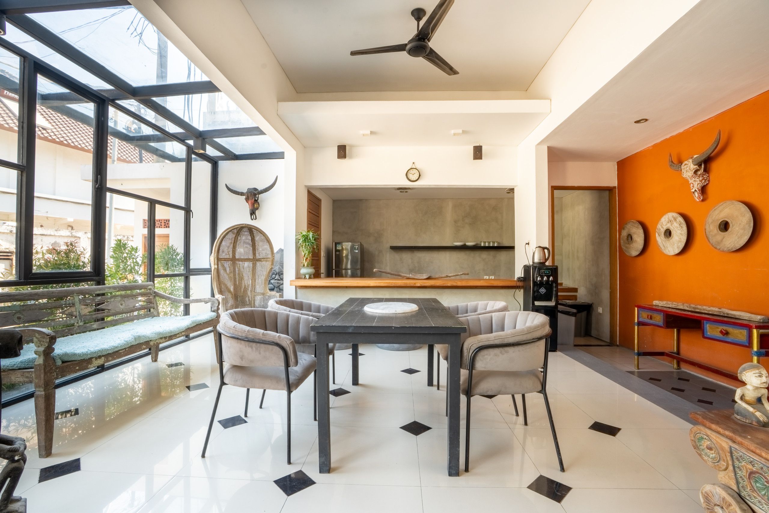 Un interior moderno con zona de comedor, cocina y vistas amplias a través de grandes ventanales.
