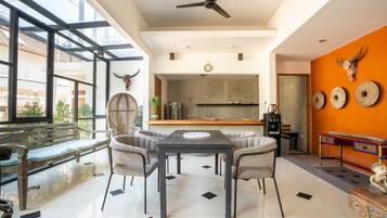 Un interior moderno con zona de comedor, cocina y vistas amplias a través de grandes ventanales.