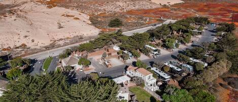 Une zone résidentielle côtière avec des maisons, des camping-cars et une plage.
