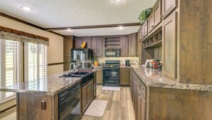 Una cocina con armarios de madera, encimera de granito y horno empotrado.