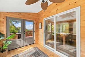 A wooden interior with a sliding glass door leading to an outdoor deck. - Mountain Views, Hot Tub near Hiking, Ski & Santa`s Village (Jefferson)