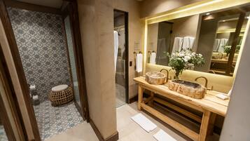 Un baño con tocador de madera, un espejo grande y un papel tapiz decorativo.