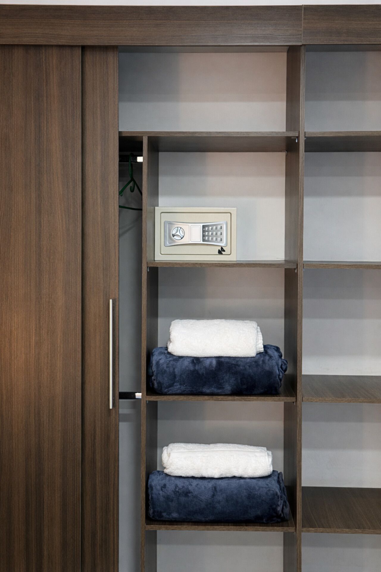 A wardrobe with a control panel, multiple shelves, and a hanging space.
