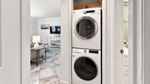 A laundry room with two stacked front-loading washing machines.