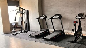 A gym with treadmills, a weight bench, and a stationary bike. - Spacious loft at amazing location! (sabaneta)