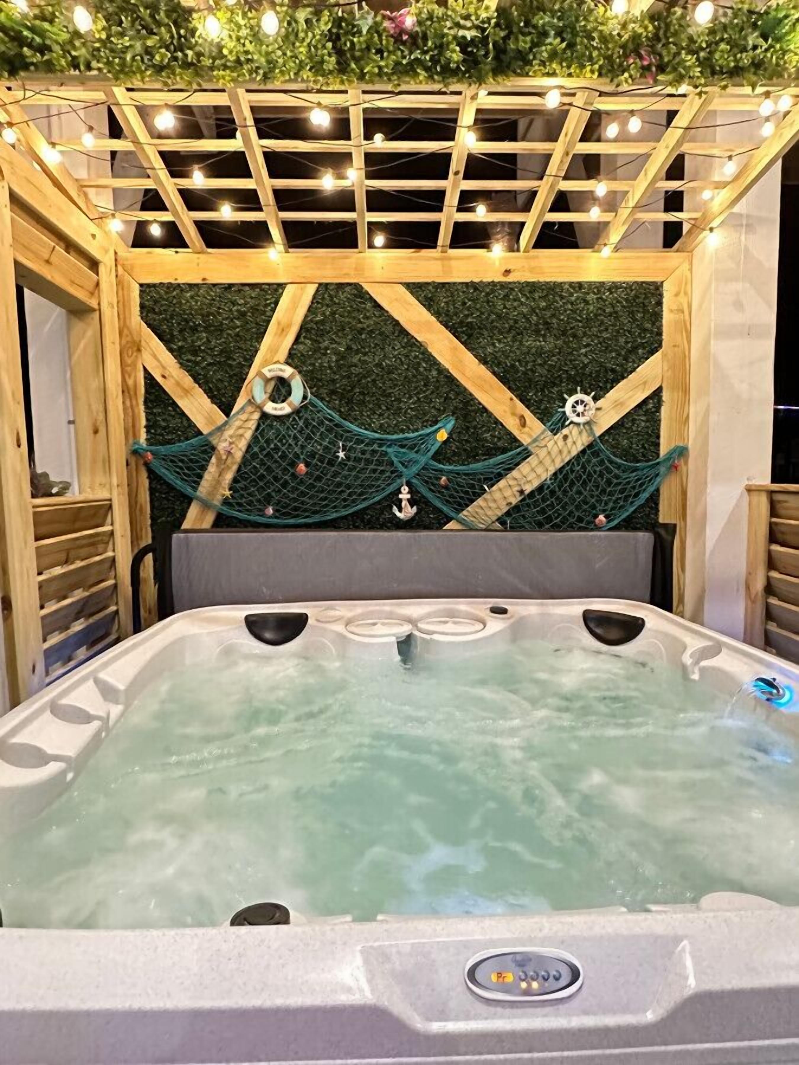 Ett bubbelbad med en träram och en grön vägg dekorerad med marintema.
