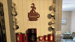 Eine Küchenzeile mit Kaffeemaschine, Tassen und einem Schild mit Tipps zur Wäsche und zum Essen.