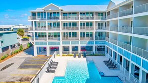 Un hôtel à plusieurs étages doté d’une piscine, de balcons et d’un parking.