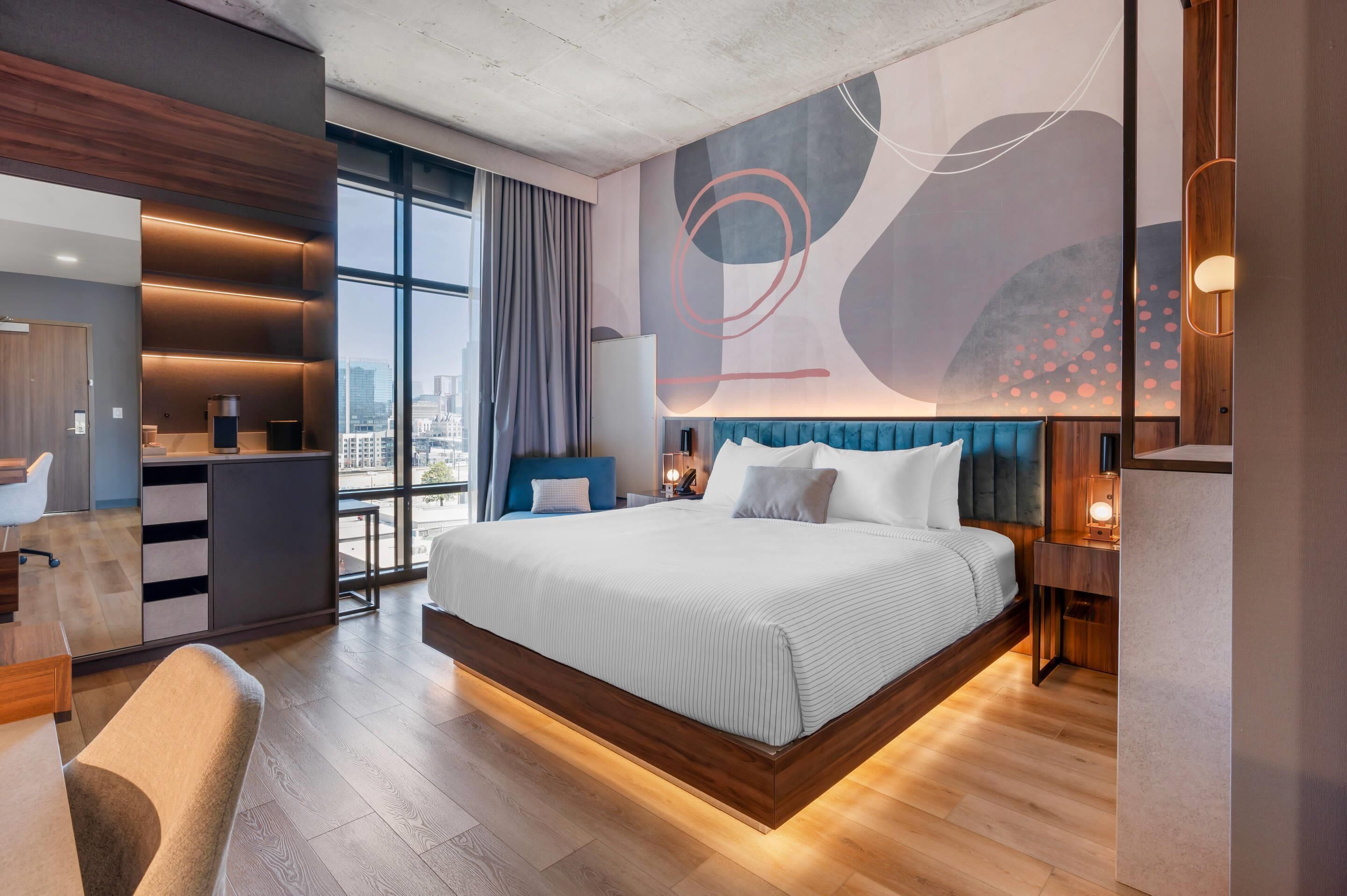 Une chambre d’hôtel moderne avec un grand lit, un bureau et une vue sur la ville.