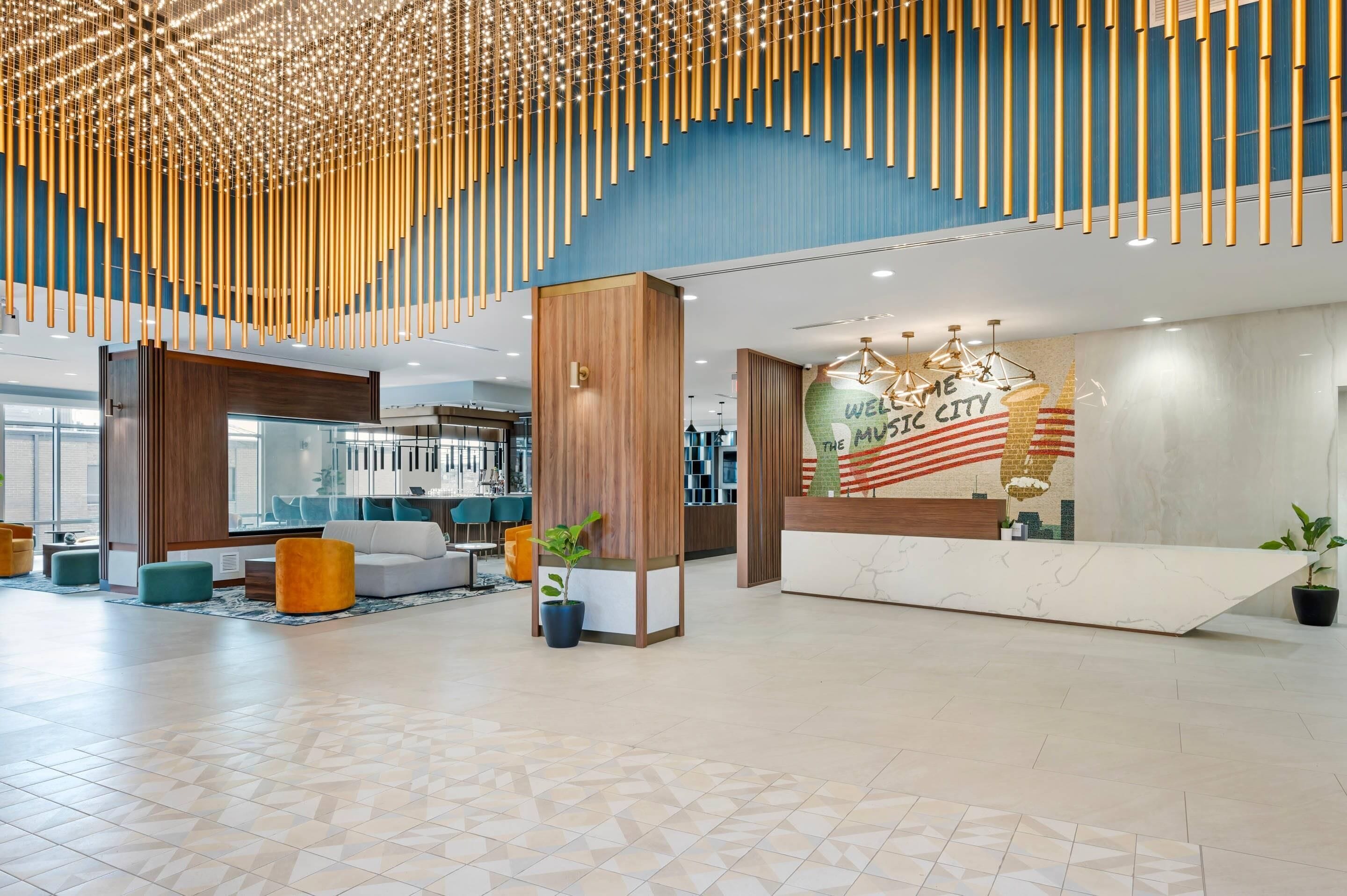 Een moderne lobby met een receptiebalie, een zithoek en een groot muurdecor.