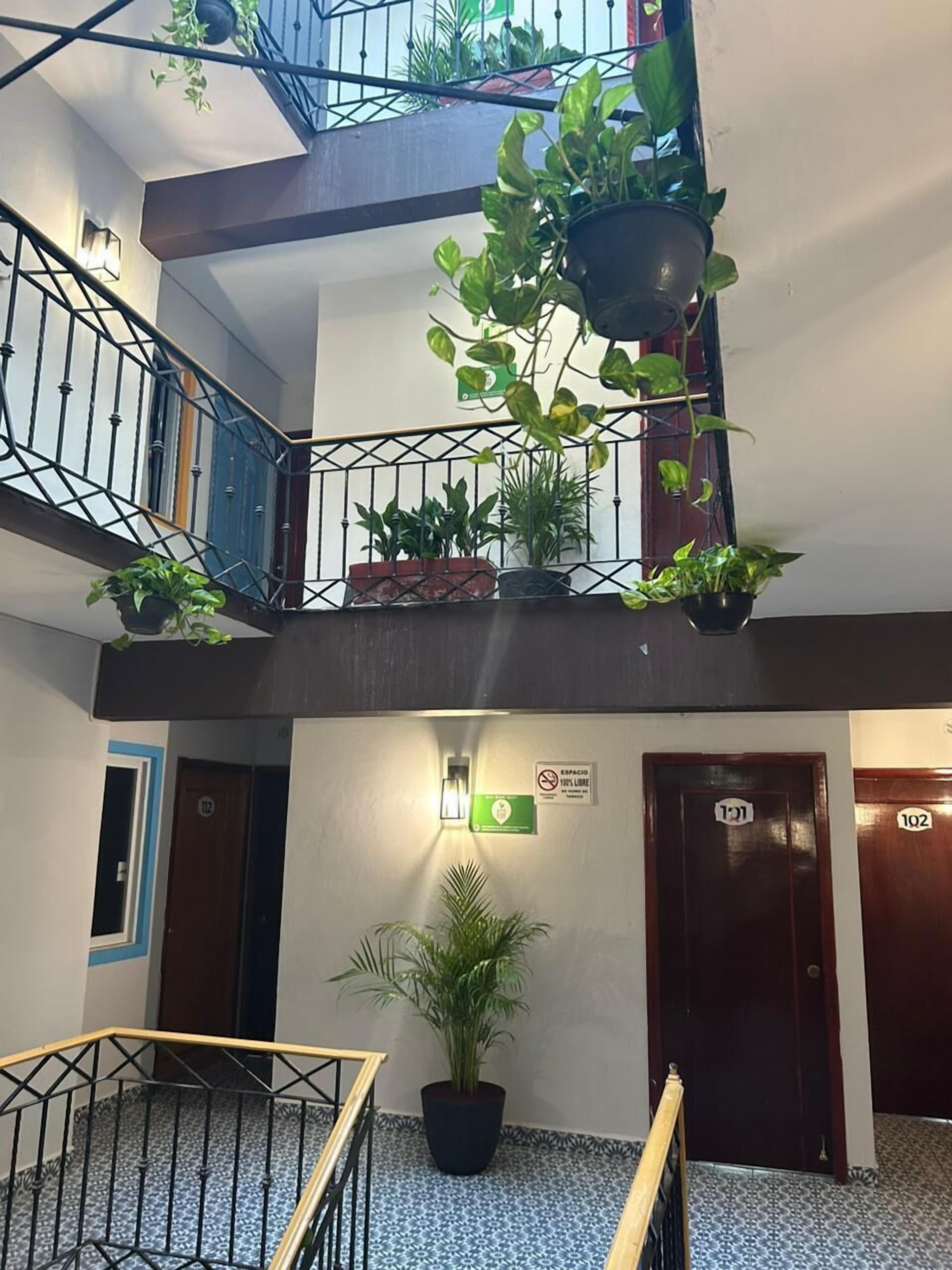 A multi-level indoor space with a staircase, potted plants, and doors labeled 121 and 122.