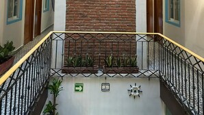 A multi-level interior with a central brick wall, a framed picture, and a ship's wheel. - Hotel Jar8 Bule (Boca del Río)