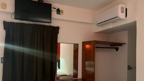 A compact hotel room with a bed, a desk, a chair, a TV, and an air conditioning unit. - Hotel Jar8 Bule (Boca del Río)