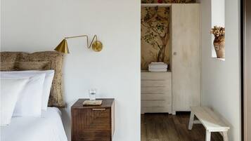 A bedroom with a bed, bedside table, and a wall-mounted lamp.