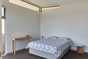 Une chambre à coucher avec un lit, une petite table et une table de chevet.