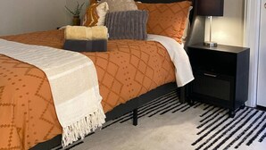 A bedroom with a bed, nightstands, a lamp, and wall art. - Charming/Cozy/1 Bedroom (Kansas City)