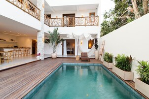 Una piscina al aire libre, sillones reclinables de piscina