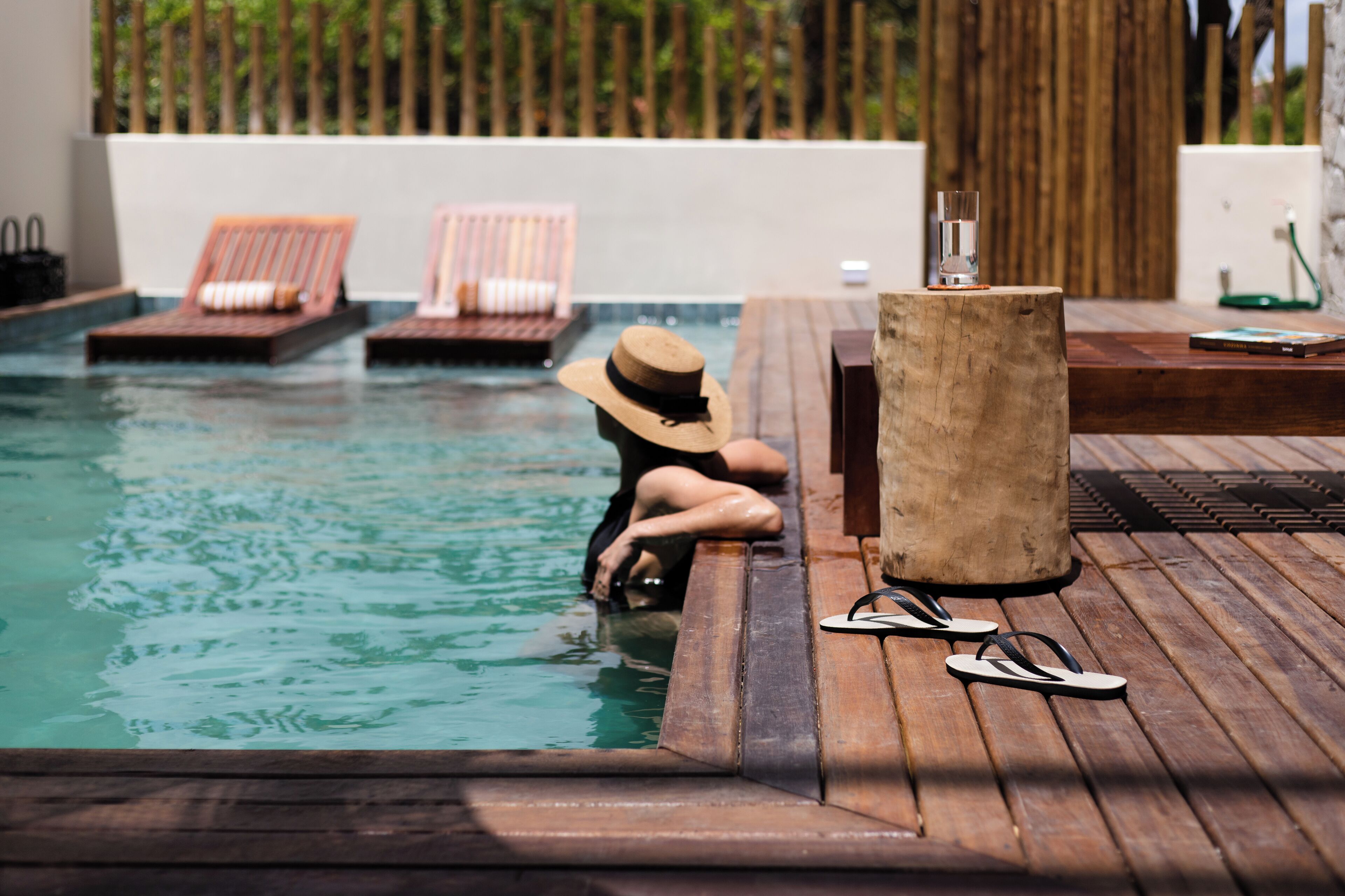 Ein Poolbereich mit Liegestühlen und einer Holzterrasse.