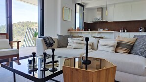 A modern living room with a glass coffee table, a sofa with patterned cushions, and a wooden side table. - ALLONBAY sun & beach penthouse (Villajoyosa)