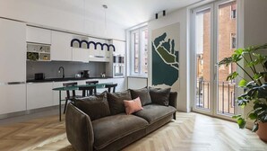 A modern apartment with a kitchenette, a dining area, and a large window with a cityscape view. - Our apartment is in a building of the past century, it's on the 2nd floor and served by an elevator.You will have at your disposal 2 bedrooms, 2 bathrooms, and a living room, with a cooking area, that will be able to accommodate up to 5 people.The livi (Roma)