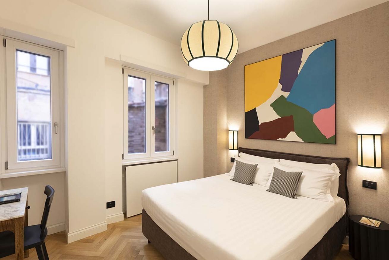 Una habitación de hotel moderna con una cama grande, un escritorio y una ventana.