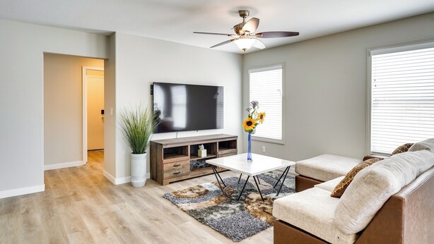 A modern living room with a flat-screen TV, a ceiling fan, a sofa, and a coffee table. - Spacious Las Vegas Home Near Casinos & Nightlife! (Las Vegas)