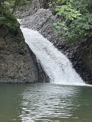Una cascada se precipita sobre un risco rocoso hacia una masa de agua.
