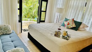 Un dormitorio con cama, sofá y vistas a zonas verdes.