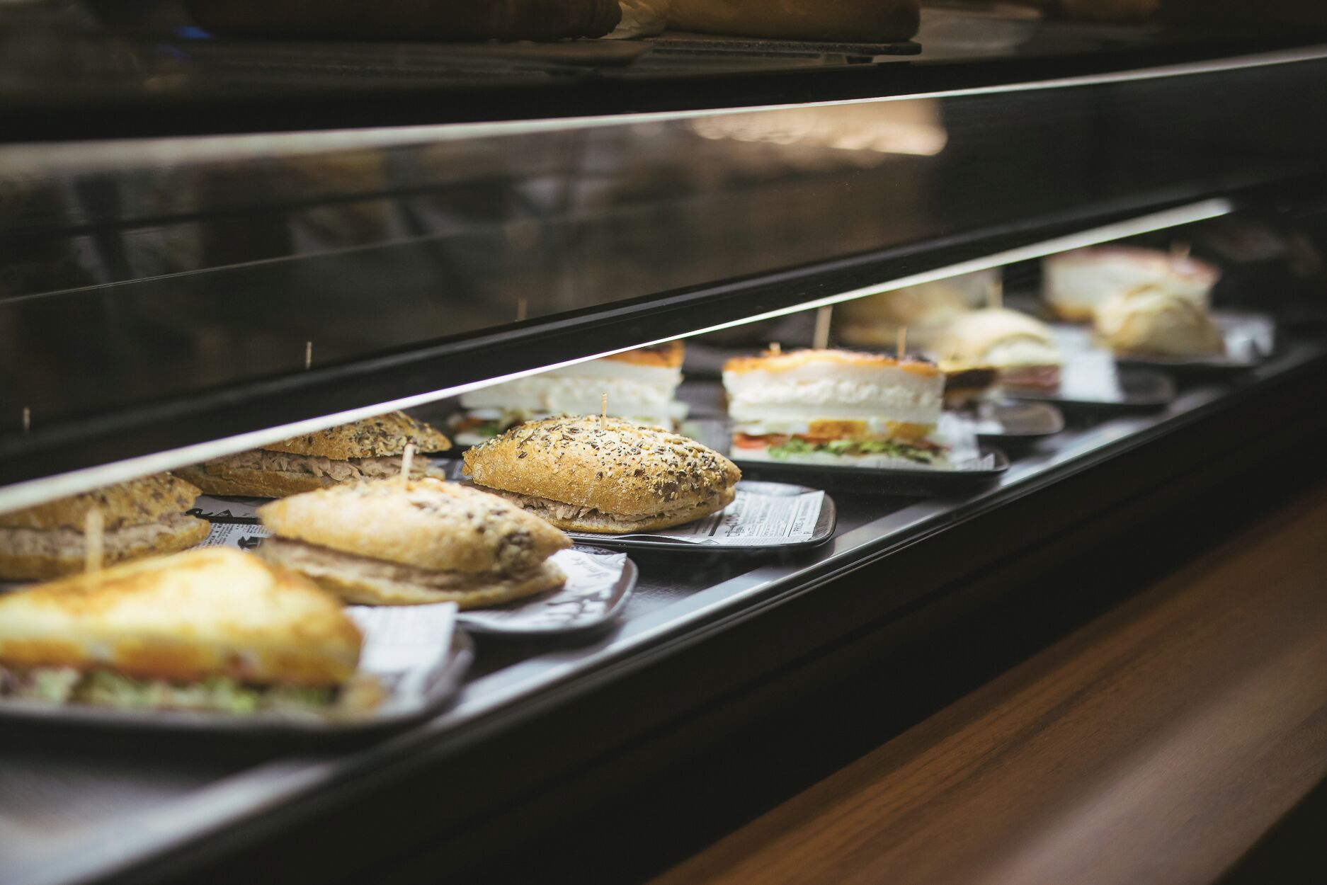 A display case with various sandwiches and salads.