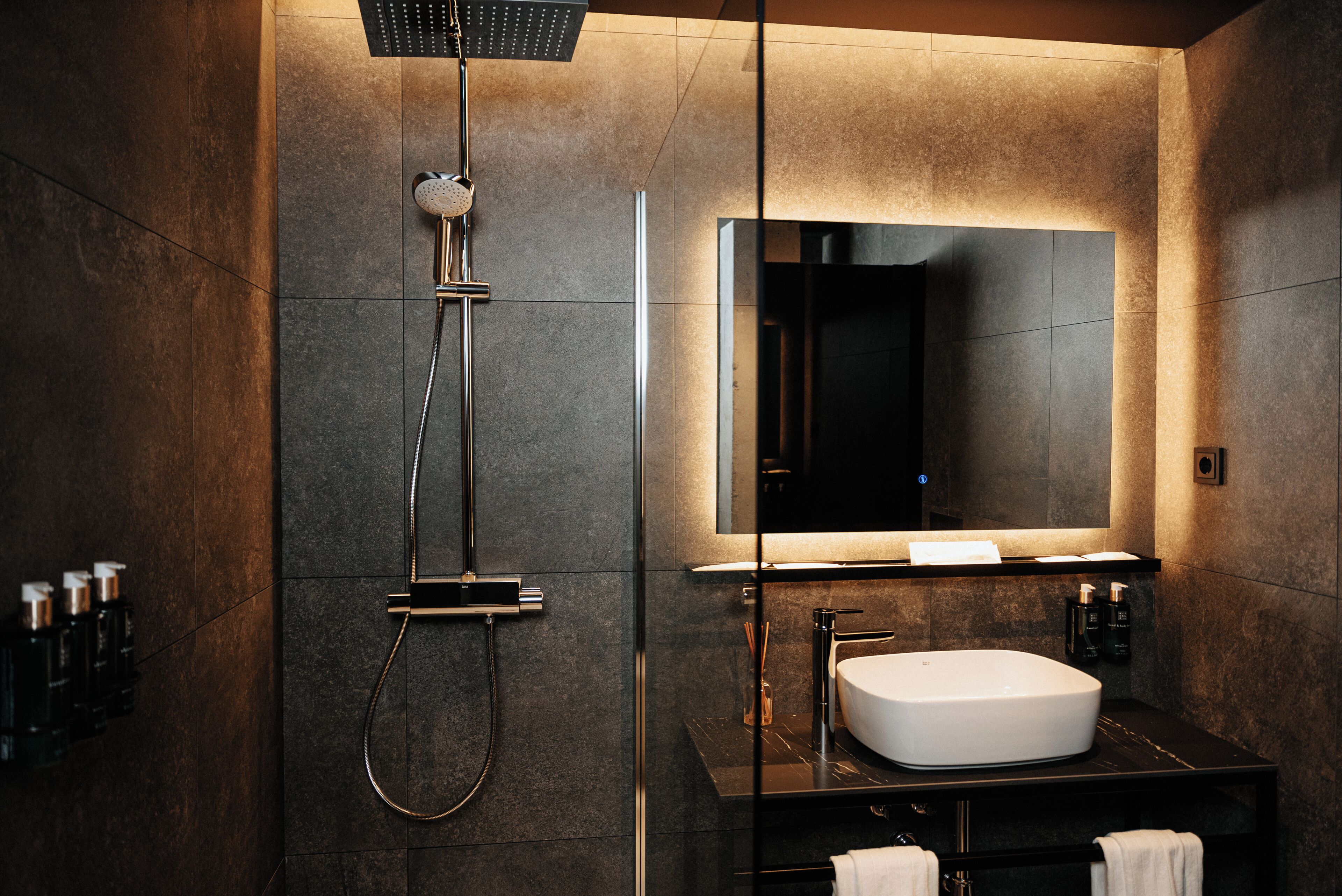 Een douche, designer toiletartikelen, een haardroger, pantoffels