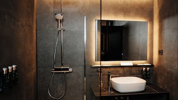 Een douche, designer toiletartikelen, een haardroger, pantoffels