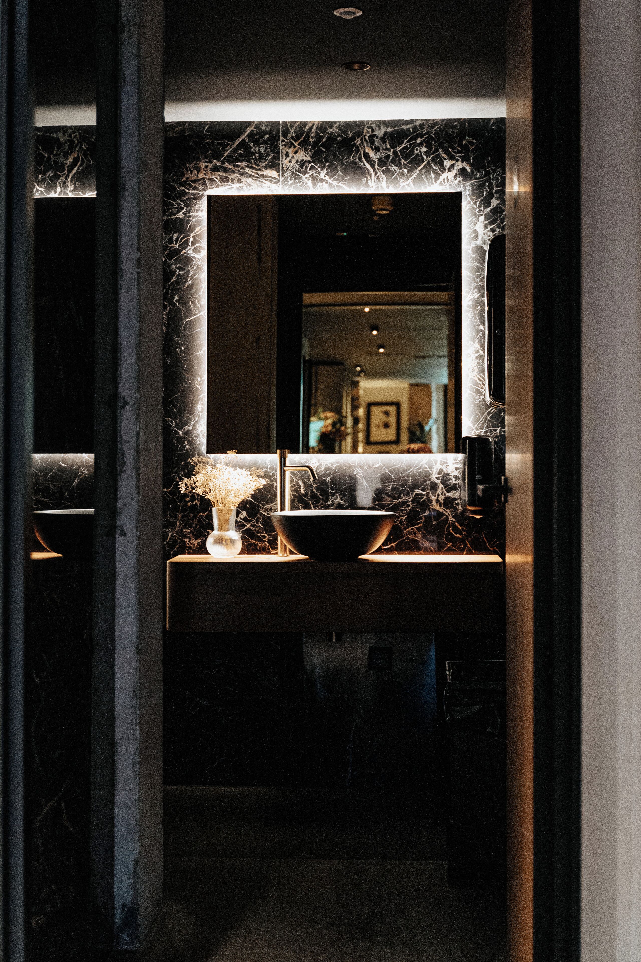A bathroom with a marble countertop, a sink, and a mirror.