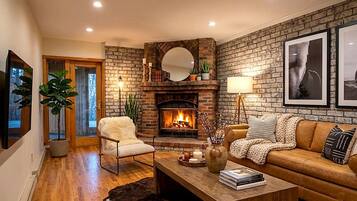 A cozy living room with a fireplace, a sofa, a coffee table, and a chair.