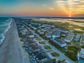 A coastal residential area with houses along the beach and a body of water.