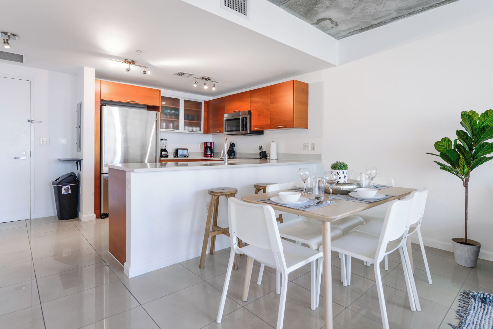 A modern kitchen with white cabinets, stainless steel appliances, and a central island.