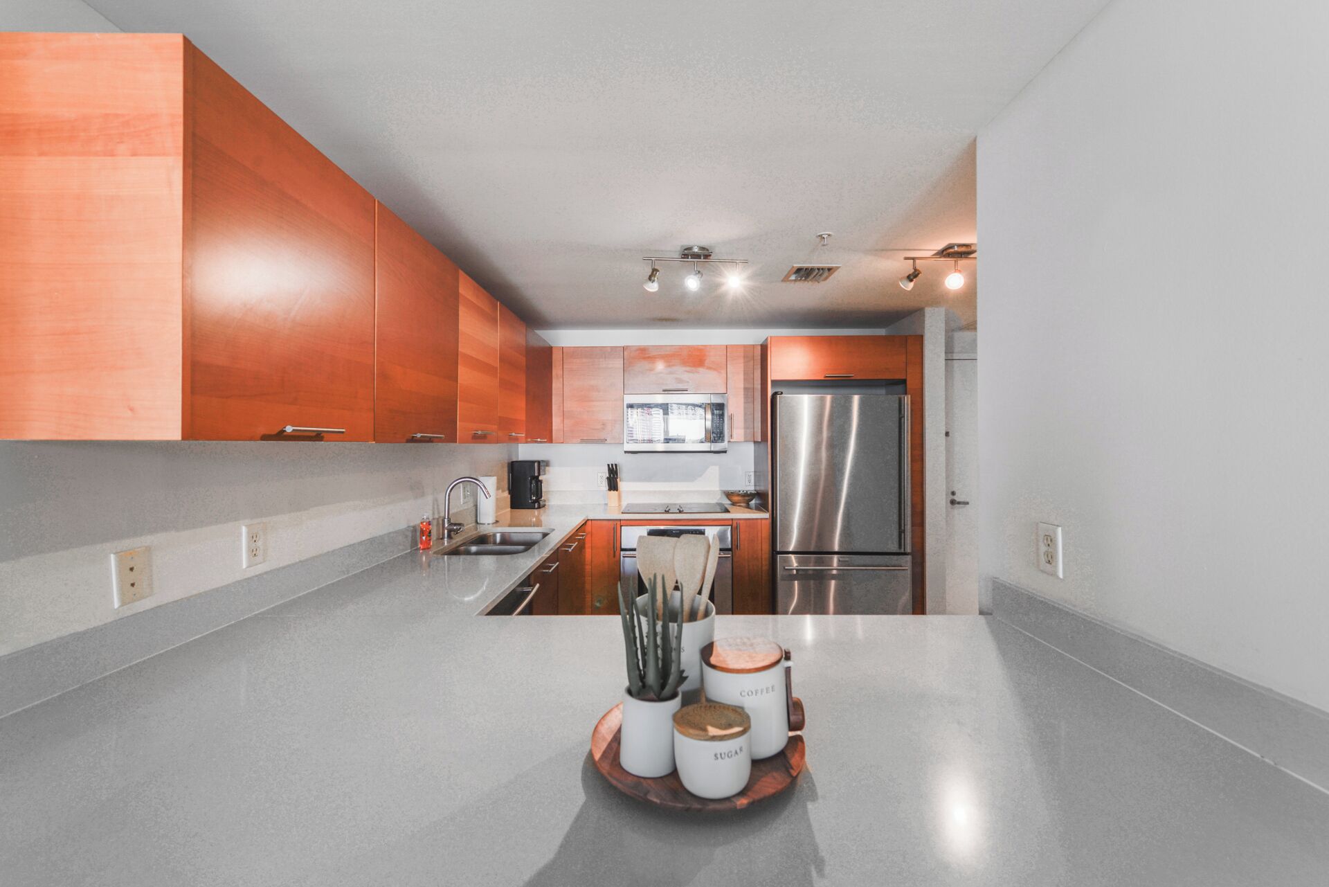A modern kitchen with wooden cabinets, stainless steel appliances, and a granite countertop.