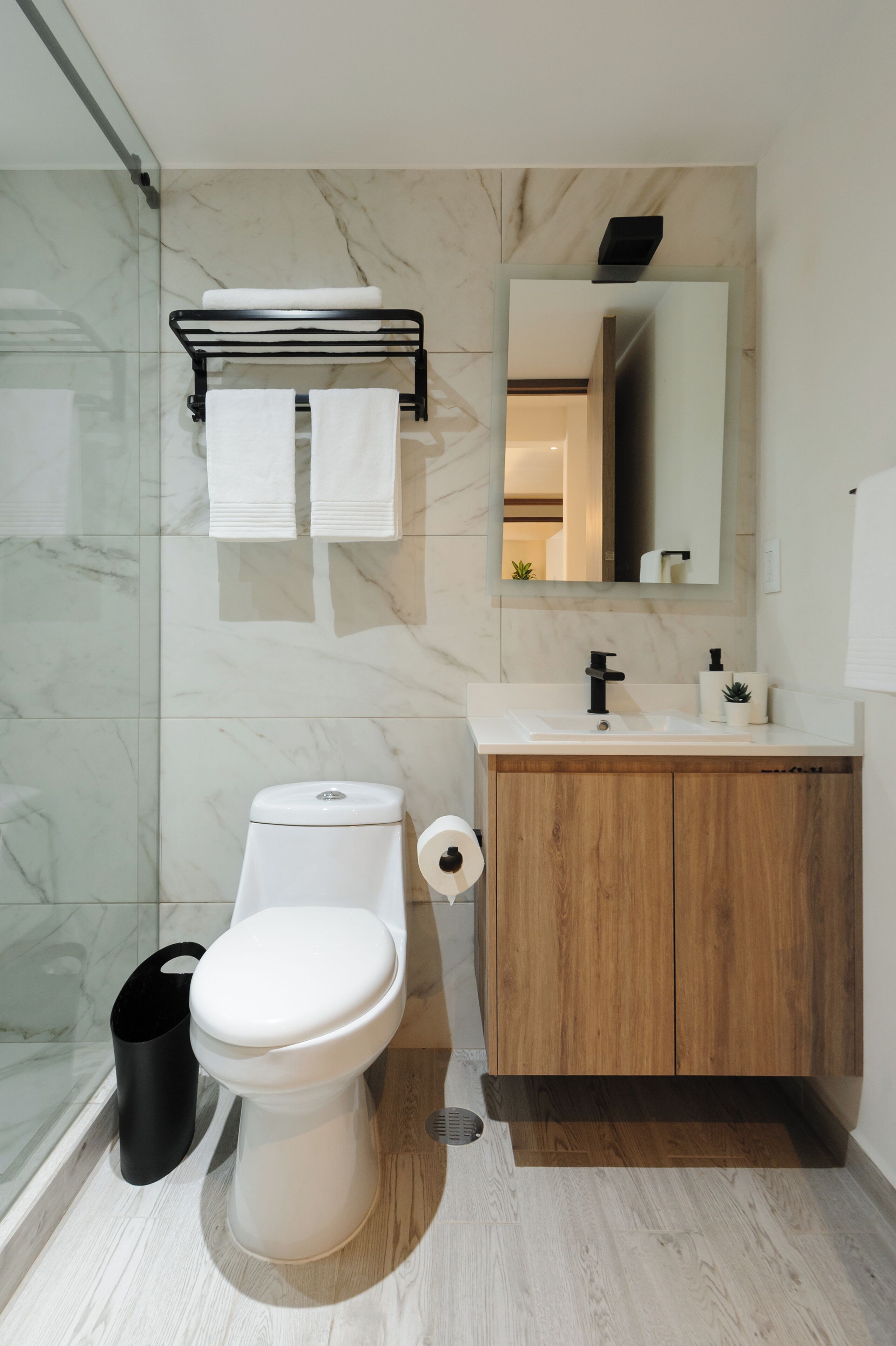 Ein modernes Badezimmer mit Toilette, Waschbecken und Spiegel.