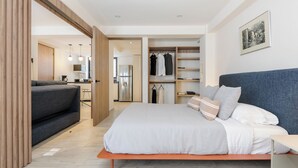 A modern bedroom with a bed, a sofa, a wardrobe, and a kitchenette. - Choapan 28 - Lux Apartments in Condesa (Mexico City)