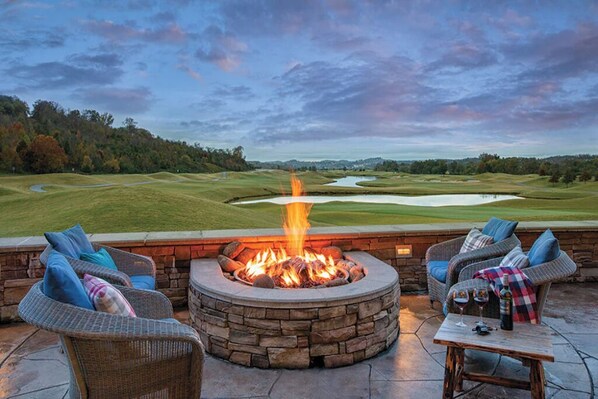 Relax in the serene outdoor seating area overlooking the golf course with a fire pit at its center.