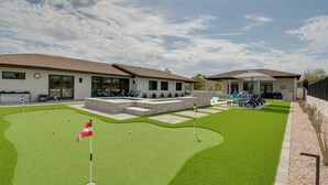 Un campo da golf con un putting green, una bandiera e un traliccio.