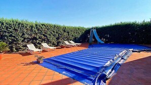 A rooftop pool area with lounge chairs, a blue slide, and a clear sky. - Relais Galatea (Montecorvino Pugliano)