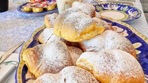 A breakfast table with pastries, a pitcher of orange juice, and a refrigerator in the background. - Relais Galatea (Montecorvino Pugliano)