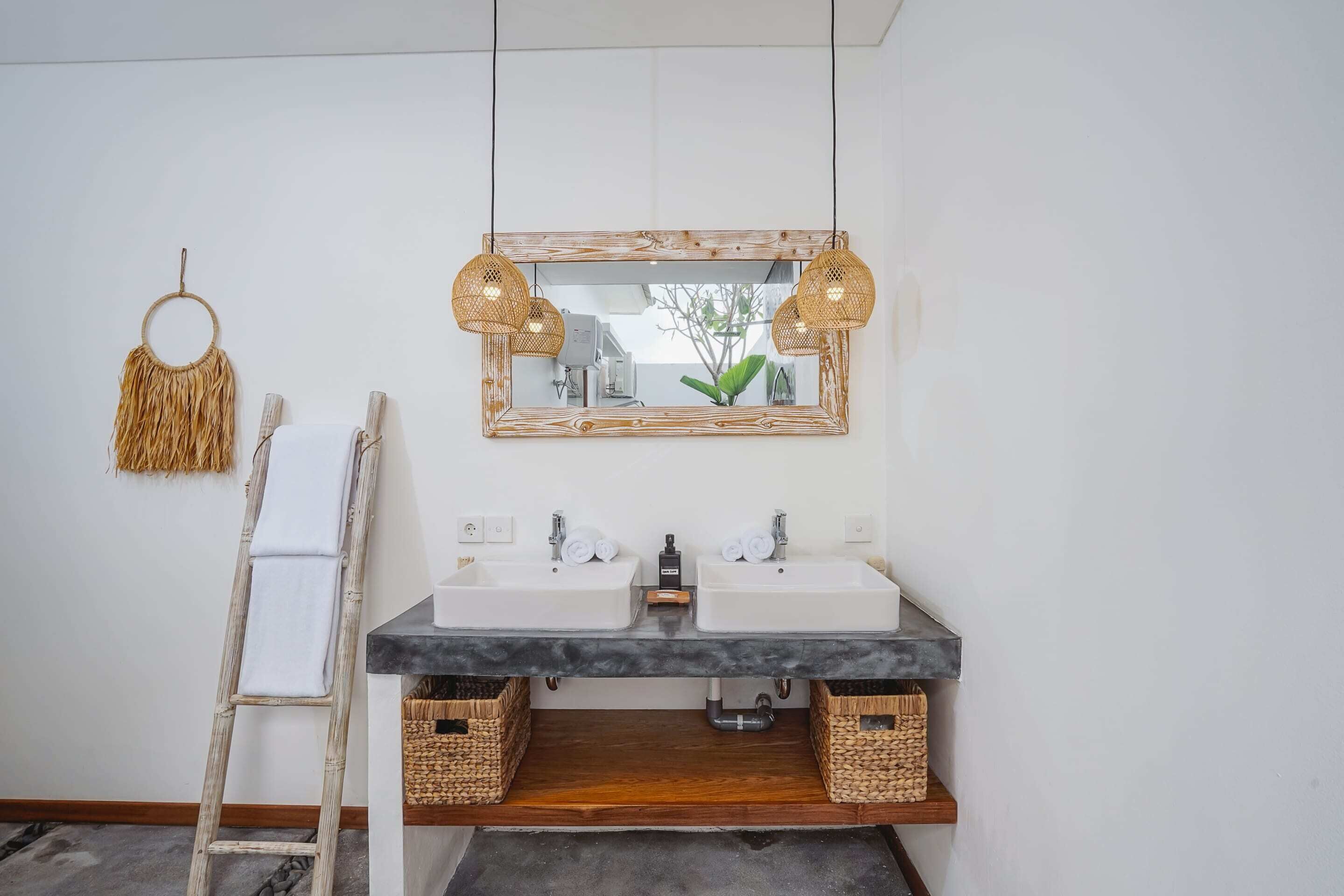 A bathroom with a wooden-framed mirror, two sinks, and a wooden ladder.