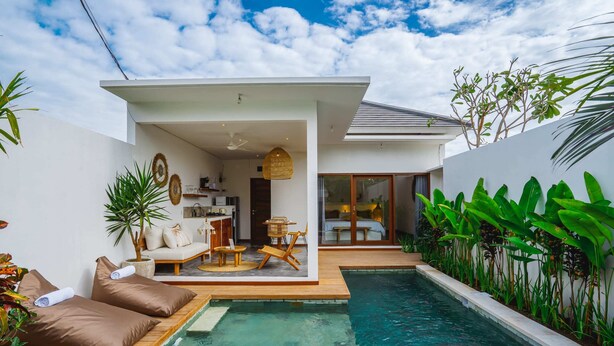 A modern house with a swimming pool, a sun terrace with lounge chairs, and a dining area. - Villa Karina (Tabanan)