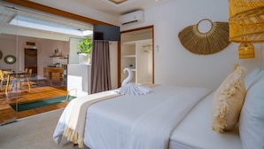 Ein modernes Hotelzimmer mit einem großen Bett, einer Essecke und Blick auf einen Pool.