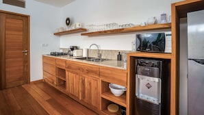 Eine moderne Küche mit Holzschränken, einer Edelstahl-Spüle und einem eingebauten Geschirrspüler.