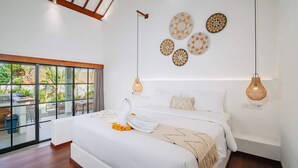 A modern bedroom with a large bed, decorative wall art, and a view of the outdoors. - Villa L at Seseh (Munggu)