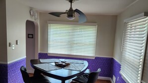 A dining area with a round table, four chairs, a ceiling fan, and a window with blinds. - 3bd Family-sized house, 5 minutes to National park, 12 minutes to the Capital. (Washington)