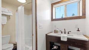 A bathroom with a shower, toilet, and sink. - Cozy King Suite at Lazy Duck Inn, just 1 minute from Yellowstone! #24 (West Yellowstone)