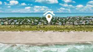 An aerial view of a coastal residential area with houses, a beach, and a clear sky. - 7223- Pelican Watch - Oceanfront Salvo | Pool & Hot Tub | Sleeps 10 (Salvo)